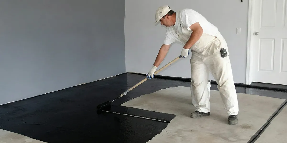 basement waterproofing professional applying waterproof coating to protect a basement floor in Evansville, IN